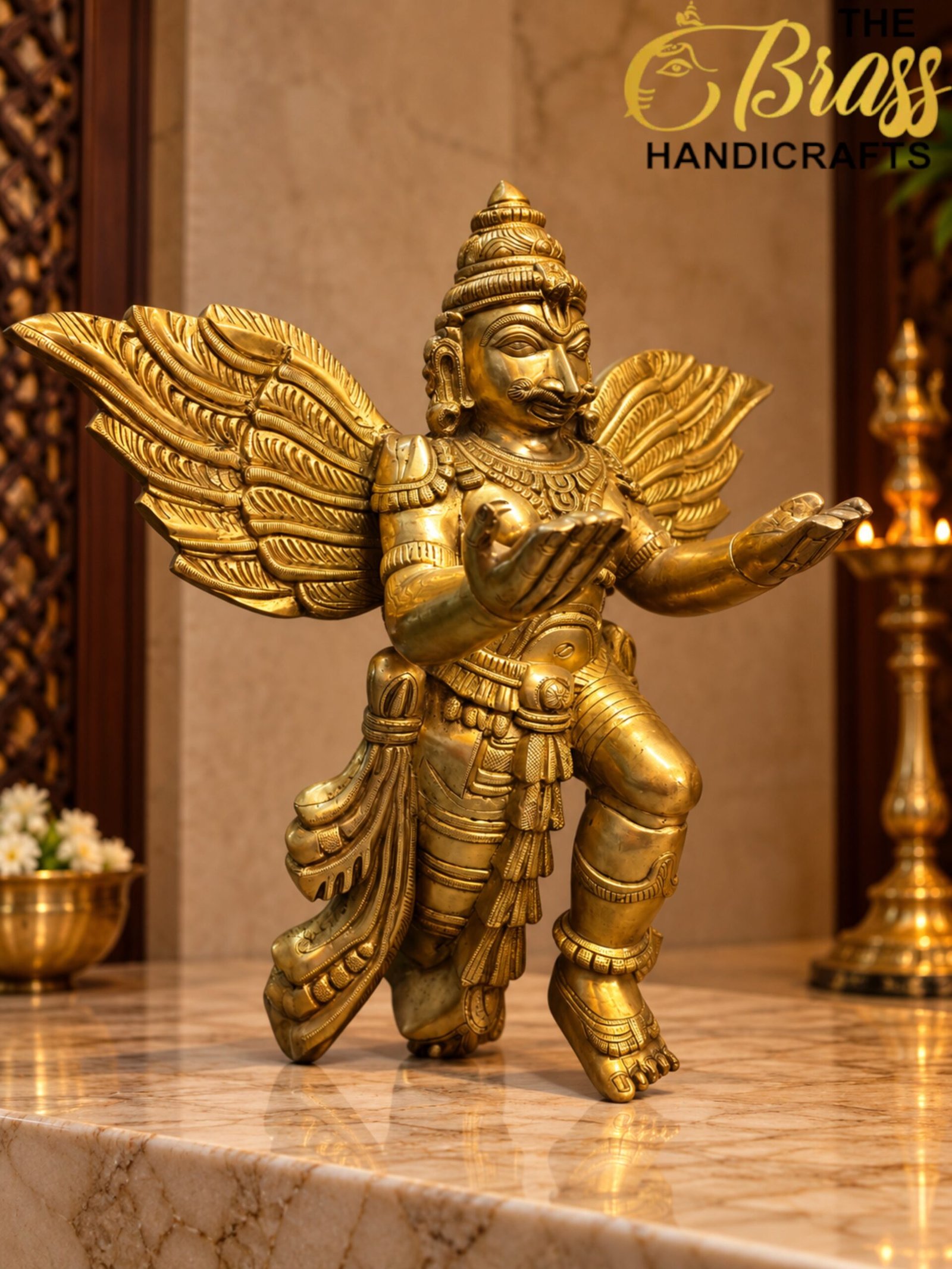 Winged Brass Deity on Marble - thebrasshandicrafts.com Golden winged deity statue on a marble pedestal in a showroom, with 'The Brass Handicrafts' logo visible in the top right corner. thebrasshandicrafts.com