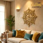il_1588xN7579738936_jvxa - thebrasshandicrafts.com Beige living room with an ornate gold wall sculpture of the Om symbol, mustard and teal pillows on a beige sofa. thebrasshandicrafts.com