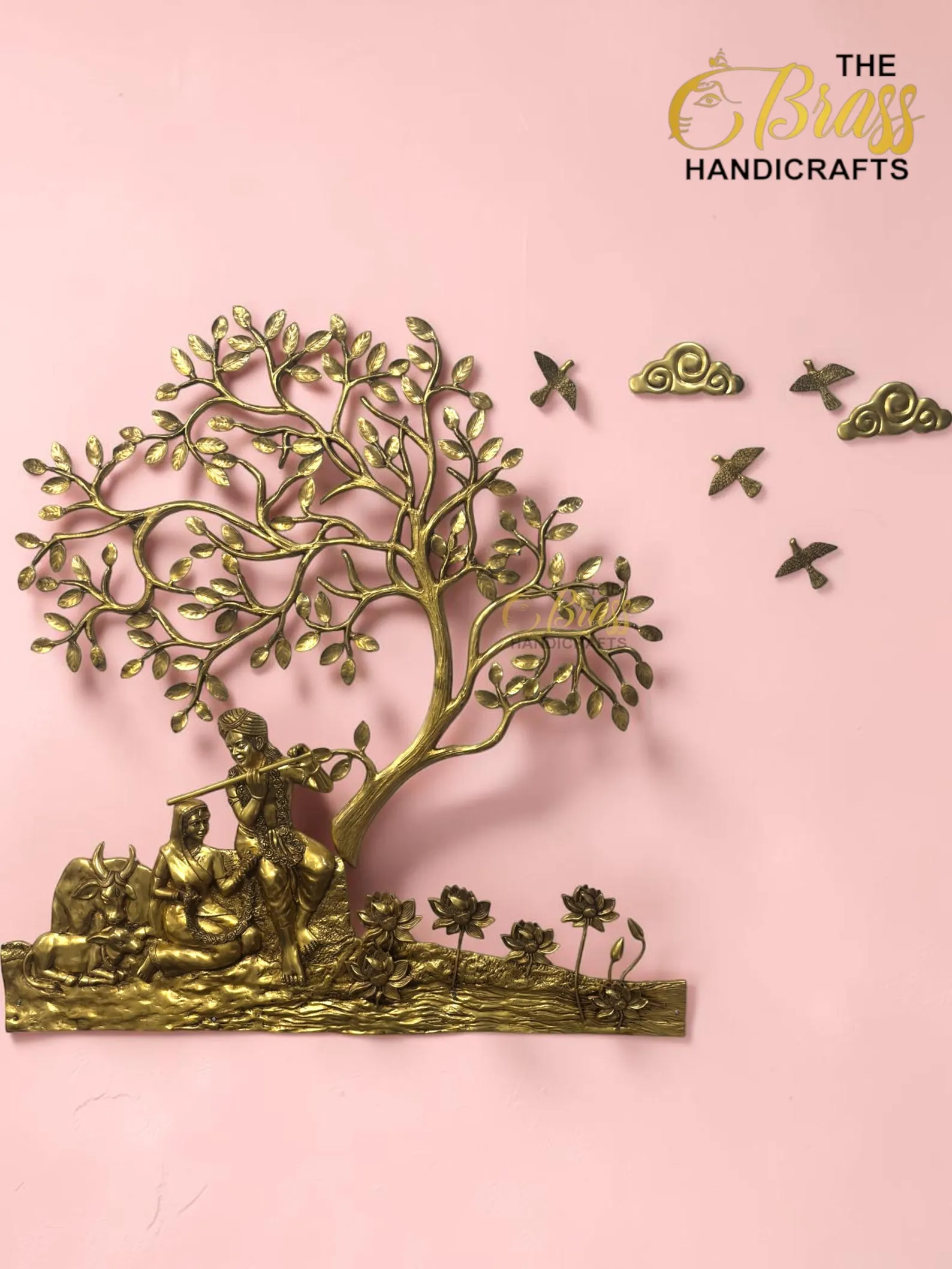 il_1588xN8398831888_msui - thebrasshandicrafts.com Gold brass tree sculpture with carved figures at its base on a pink background, with The Brass Handicrafts branding nearby. thebrasshandicrafts.com