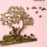 il_1588xN8446713239_b6u1 - thebrasshandicrafts.com Brass tree sculpture with a seated couple beneath branches on a pink background; logo The Brass Handicrafts in the corner. thebrasshandicrafts.com